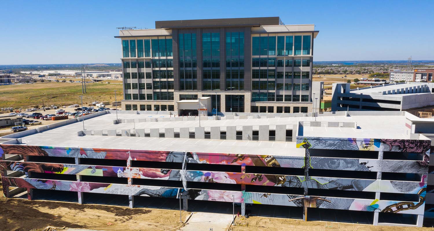 Image of the Arthurian style mural located on the parking structure and the offices at The Realm